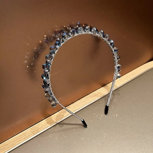 Vue détaillée de perles en cristal gris-bleu sur un serre-tête fin en métal argenté antidérapant