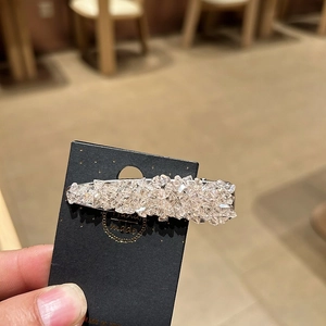 Close-up of handmade sparkling rhinestone hair clip with silver crystal gravel finish