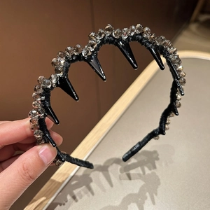 Dettaglio cerchietto nero a onde con perline di cristallo e scritta HAND MADE