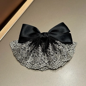 Detail of French chic black satin bow hair clip with silver lace floral embroidery