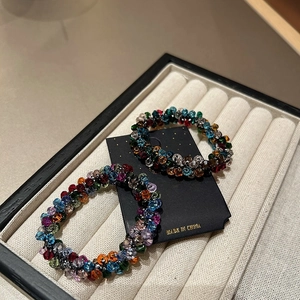 Close-up of vibrant faceted crystal beads on elastic hair bands in a display tray