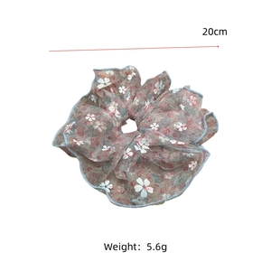 Vue détaillée du chouchou en organza fleuri montrant le diamètre de 20 cm et le tissu léger