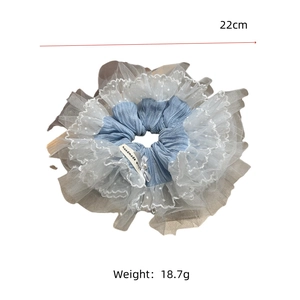 Détail d'un chouchou bleu de 22 cm avec dentelle, étiquette faite main et perle