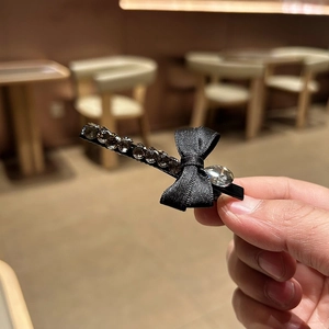 Gros plan détaillé d'une barrette à nœud en velours vintage avec strass gris de luxe