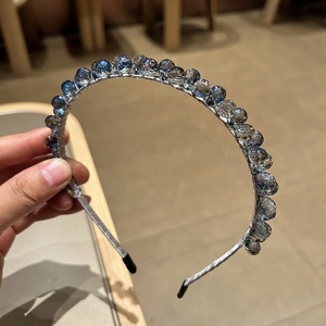 Détail du serre-tête élégant en cristaux avec des perles de verre facettées dégradées