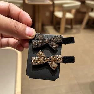 Detail of black velvet hair clips set with sparkling rhinestones in bow design