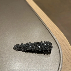 Detail view of sparkling black crystal rhinestones on elegant duckbill hair clip