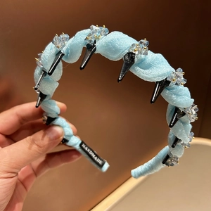 Detail of light blue mesh headband with crystal beads and handmade interior label