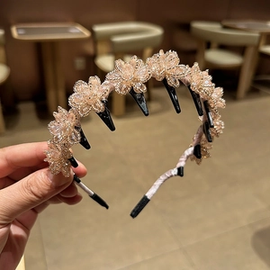 Detail of beaded crystal floral headband featuring black hair clips for hair styling