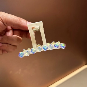 Détail de la pince à cheveux crème ornée de fleurs en cristal aux couleurs vives