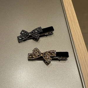 Detail of sparkling rhinestone bow hair clips with elegant black velvet base texture