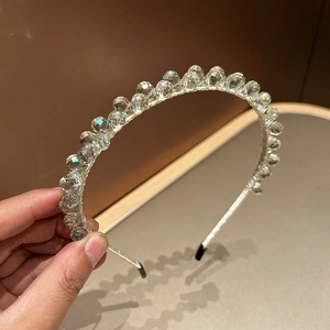 Macro detail of hand-beaded crystal headband with clear faceted beads on a slim frame