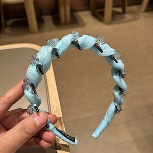 Light blue twisted fabric headband with crystal accents and handmade label