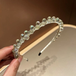 Detailed macro view of handcrafted crystal beads and light-colored threading on the headband