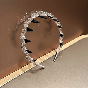 Dettaglio del cerchietto in raso rosa con cristalli e punte nere in stile punk