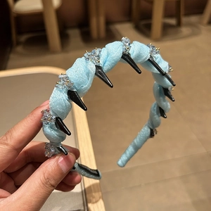 Detail of light blue twisted fabric headband with crystal beads and non-slip inner teeth