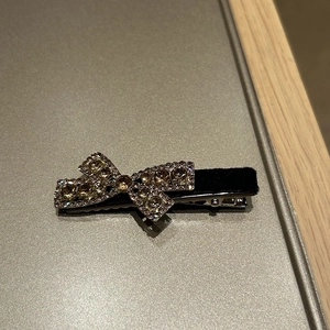 Detailed macro view of black velvet bow hair clip with luxury sparkling rhinestones
