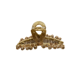 Pince à cheveux élégante en tissu doré avec perles de cristal champagne sur fond blanc