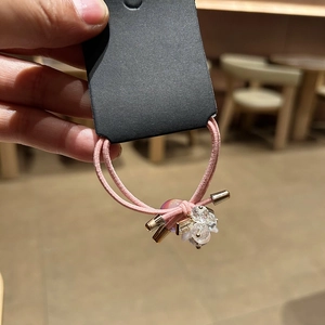 Pink elastic hair tie with a round crystal flower and colorful laser bead on a card