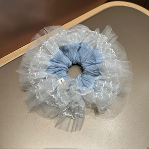Vue détaillée du chouchou en tulle double couche avec pois et tissu bleu plissé