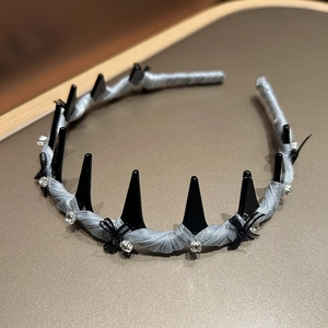 Detail view of punk spike hairband with black lace bow and silk fabric wrapping