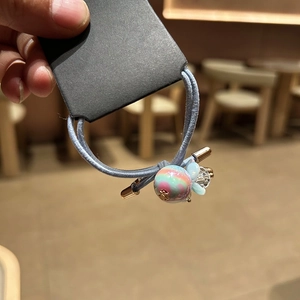 Detail of light blue elastic hair tie with crystal cut beads and spiral textured charm