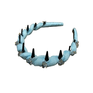 Light blue fabric headband with crystal accents and dark studs on a white background