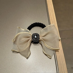 Close-up of champagne mesh bow hair tie with vintage black rhinestone centerpiece