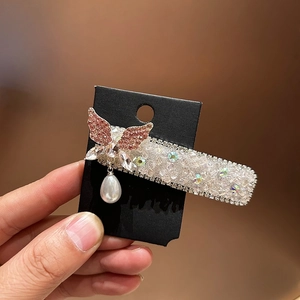 Eleganter Schmetterlings-Haarclip mit rosa Strasssteinen und Perle auf einer Karte
