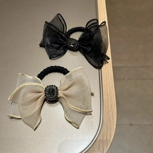 Detail of mesh bow scrunchies with sparkling rhinestones in black and champagne gold