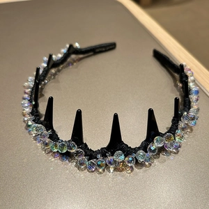 Dettaglio del cerchietto di lusso con punte nere e perle di cristallo iridescenti