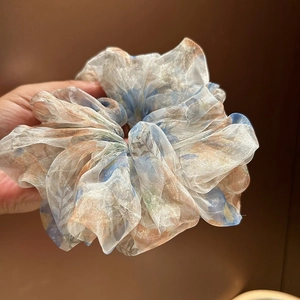 Vue détaillée du chouchou en maille avec dégradé de fleurs bleu pastel et rose