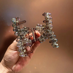 Détail d'une pince à cheveux faite main avec perles en cristal violet sur métal doré