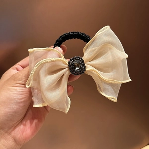 Close-up of champagne mesh bow hair tie with a black rhinestone centerpiece