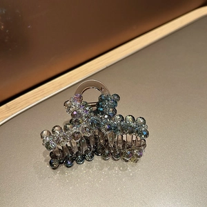 Vue détaillée de perles en cristal sur une pince à cheveux marron avec ressort métallique