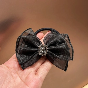 Detail of black organza bow hair tie with a sparkling center crystal and small rhinestones