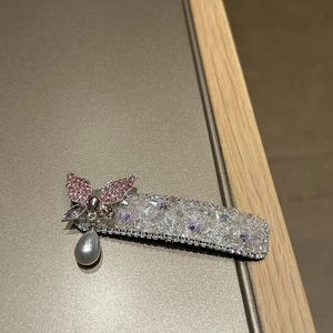 Makroansicht einer glitzernden Kristall-Schmetterlings-Haarspange mit Tropfenperle