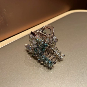 Gros plan d'une pince à cheveux en cristal dégradé bleu avec finition en fil tissé