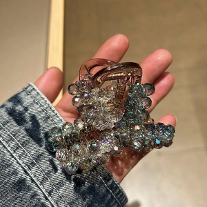 Détail de la pince à cheveux avec perles de cristal irisé et ressort doré brillant