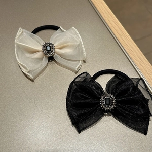 Detailed view of elegant organza bow hair clips with central rhinestone and black stone