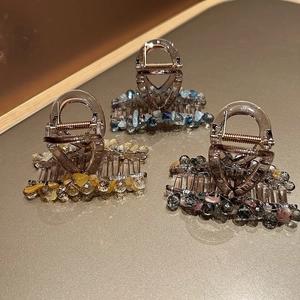 Vue détaillée de trois pinces à cheveux en résine avec perles colorées et ressort