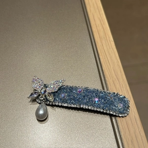 Detailansicht einer blauen Strass-Haarklammer mit Silber-Schmetterling und Perlenanhänger