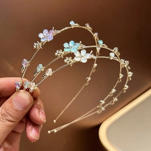 Détail de trois serre-têtes dorés avec décorations florales et feuilles irisées