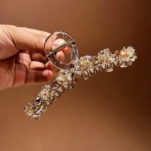 Détail macro de la grande pince à cheveux en cristal rose avec strass ambre et acrylique