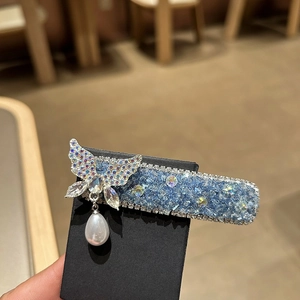 Detail einer blauen Kristall-Haarklammer mit Schmetterling und Tropfenperlen-Anhänger