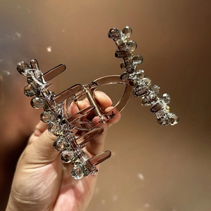 Detail of amber resin hair claw clip with faceted clear crystal beads and metal spring
