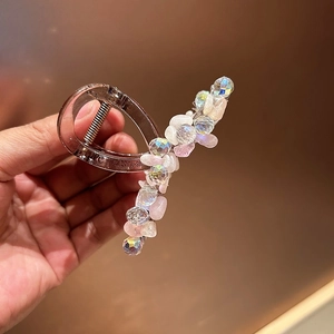 Détail de la pince à cheveux en résine ambrée avec perles colorées et éclats roses