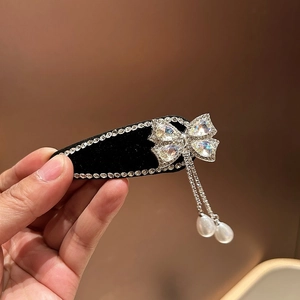 Detail van elegante strik haarklem met kristallen kettingen en pareldruppels