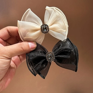 Close-up of elegant organza bow hair clips with centered vintage gemstones and rhinestones
