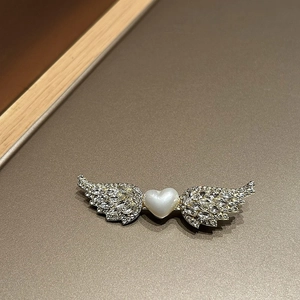 Detalle de pinza para el pelo corazón alado con cristales brillantes y perlas finas